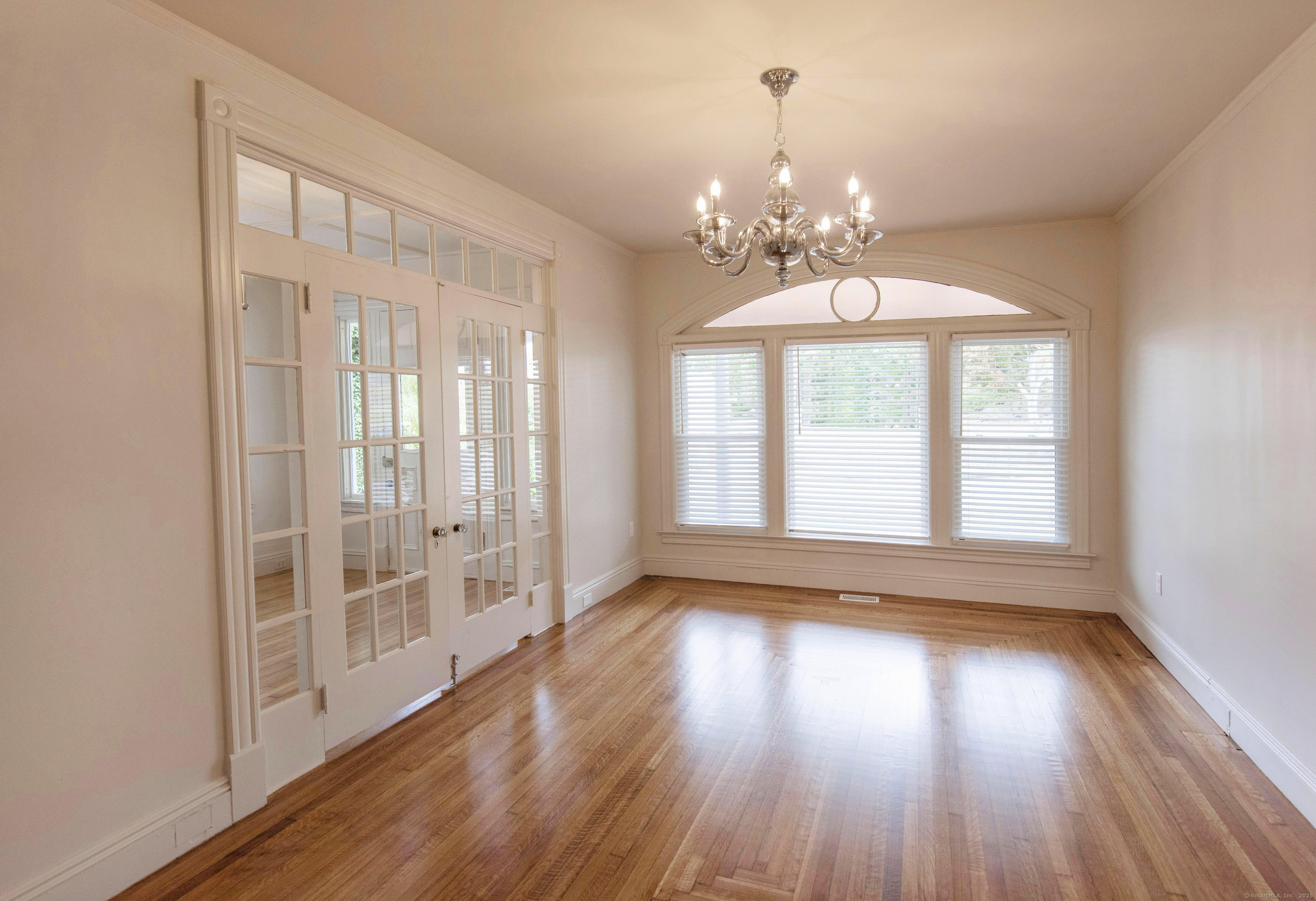 87 Broad Street Norwich, CT 06360 - Photo 13 of 29 a view of an empty room with wooden floor and a window