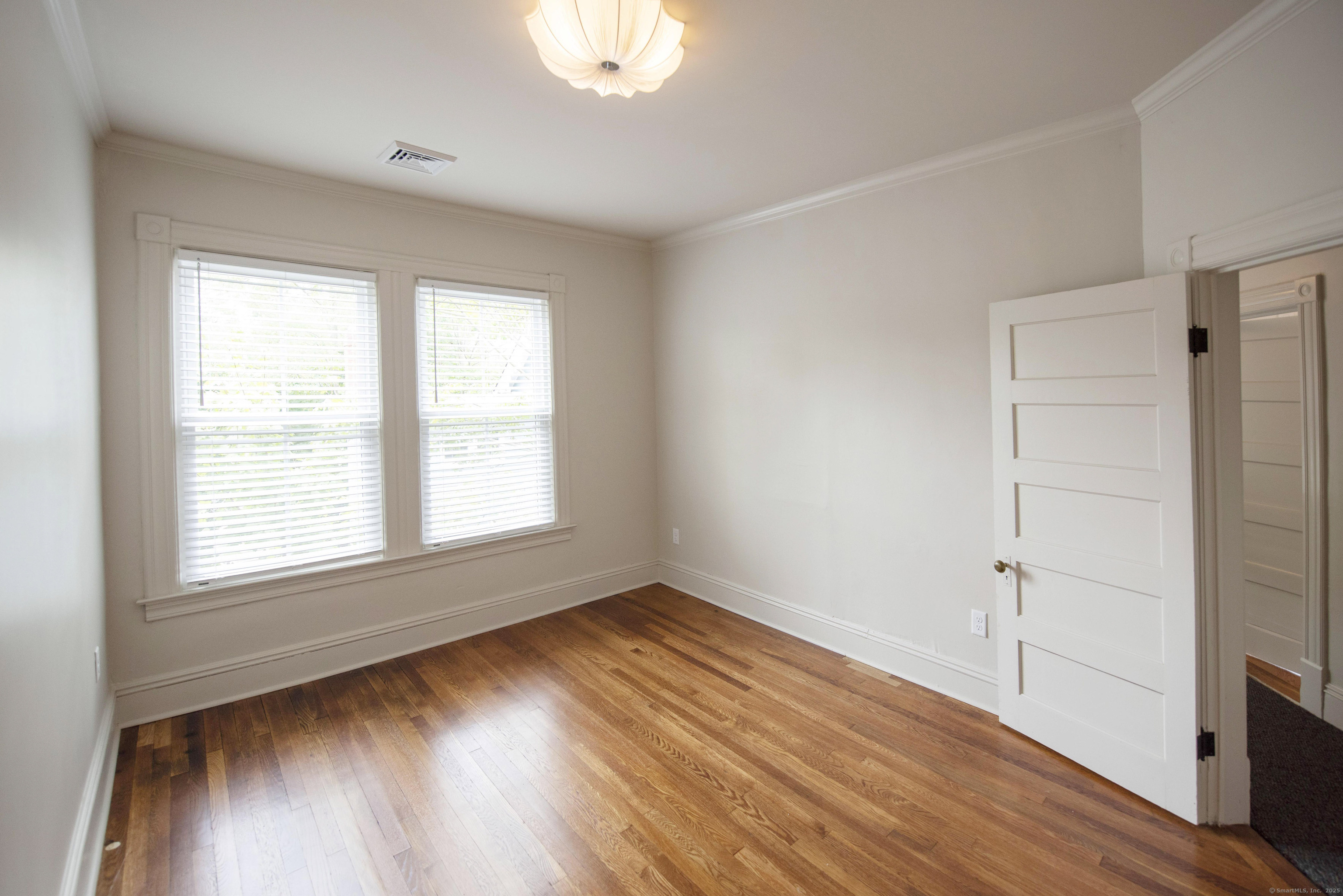87 Broad Street Norwich, CT 06360 - Photo 15 of 29 an empty room with wooden floor and windows