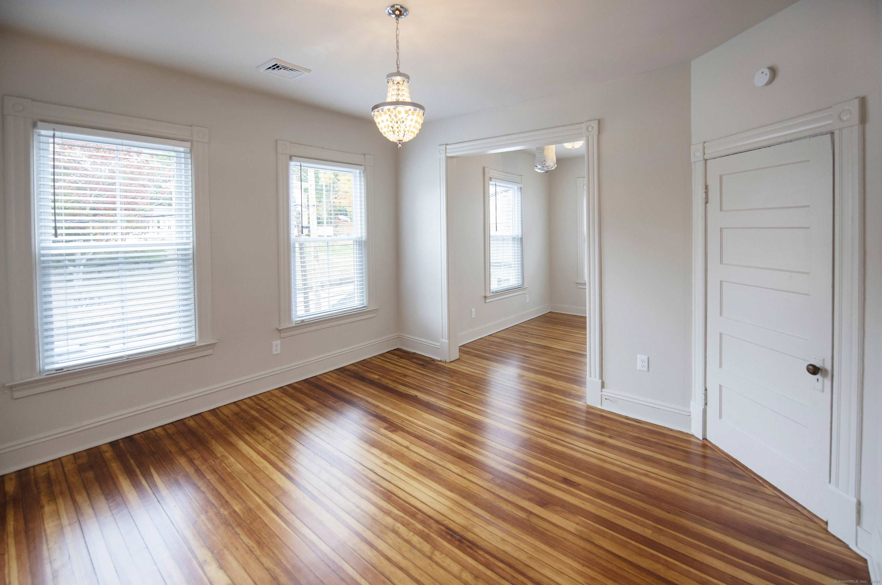 87 Broad Street Norwich, CT 06360 - Photo 22 of 29 a view of an empty room with wooden floor and a window