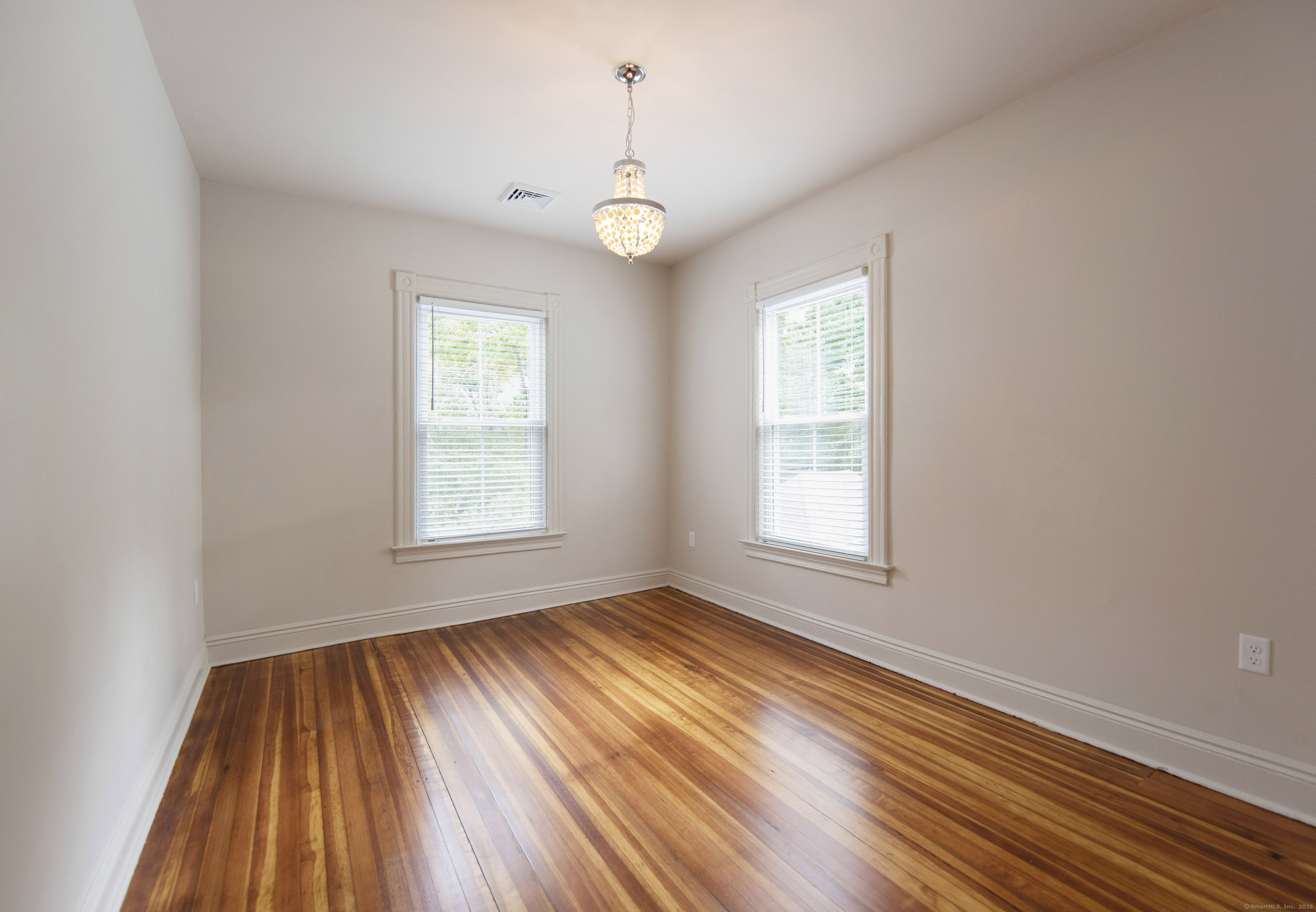 87 Broad Street Norwich, CT 06360 - Photo 29 of 29 a view of an empty room with wooden floor and a window