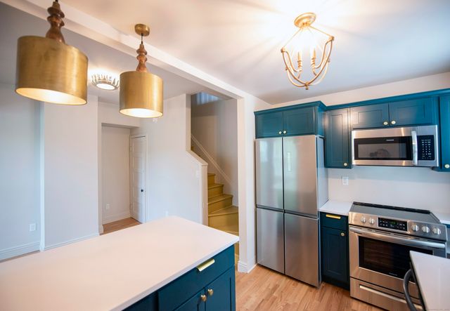 a kitchen with kitchen island a counter space a sink and appliances