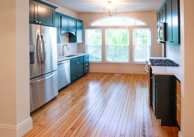 a kitchen with kitchen island wooden floor center island and stainless steel appliances