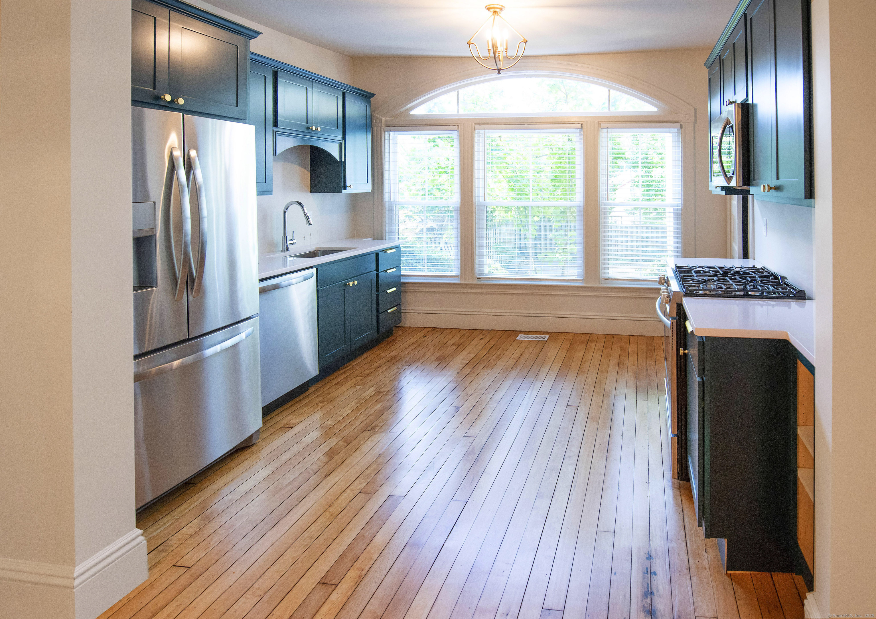 87 Broad Street Norwich, CT 06360 - Photo 10 of 29 a kitchen with kitchen island wooden floor center island and stainless steel appliances