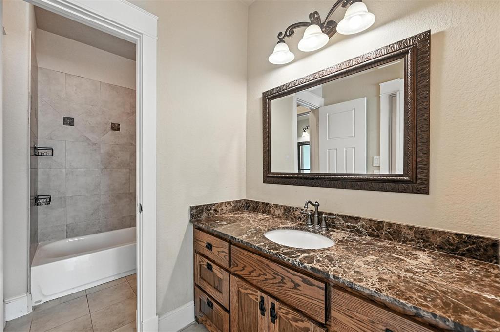 5535 Willis Avenue Dallas, TX 75206 - Photo 11 of 22 a bathroom with a granite countertop sink a mirror and a shower