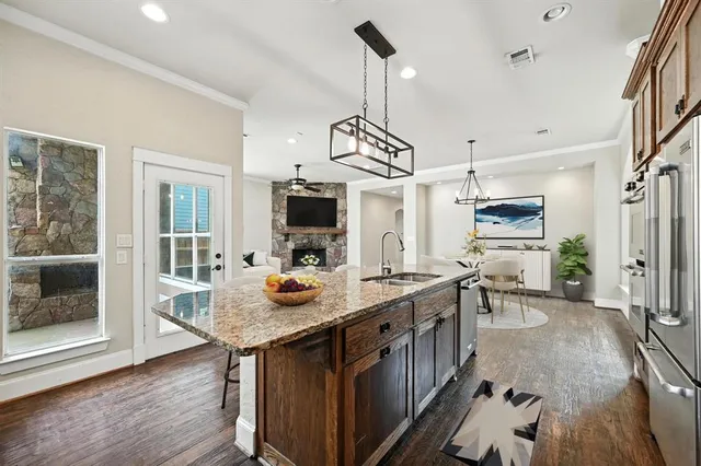 a open kitchen with stainless steel appliances granite countertop a sink stove and wooden floor