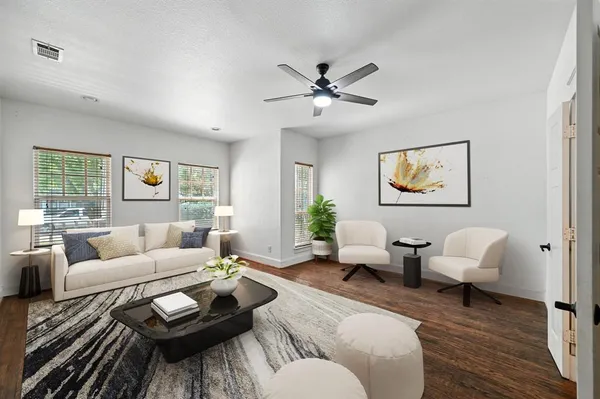 a living room with furniture and a wooden floor