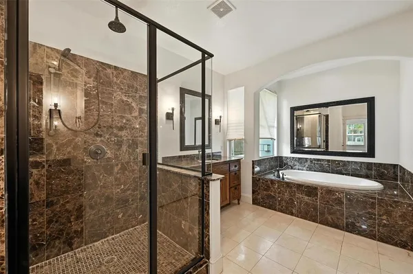 a spacious bathroom with a tub a sink and mirror
