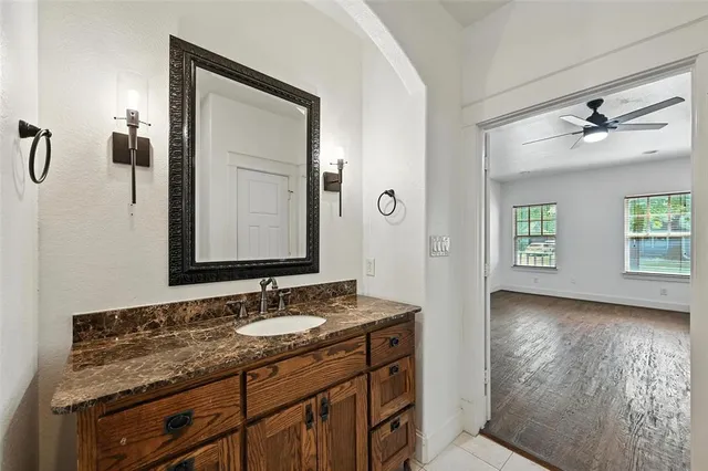 a bathroom with a granite countertop sink a mirror and a shower