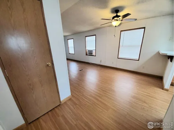 a view of a livingroom with wooden floor and a ceiling fan