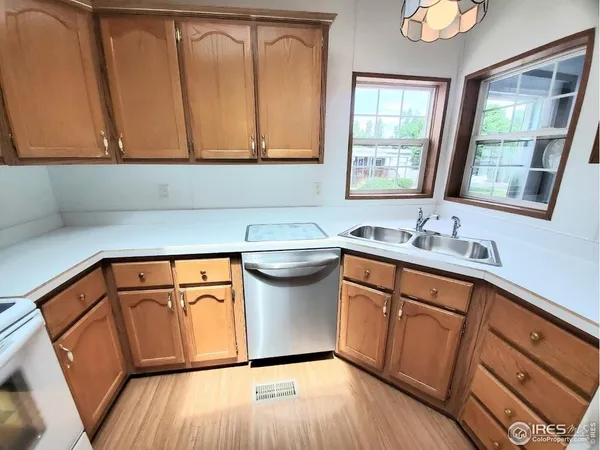 a utility room with stainless steel appliances granite countertop a sink a stove cabinets and wooden floor