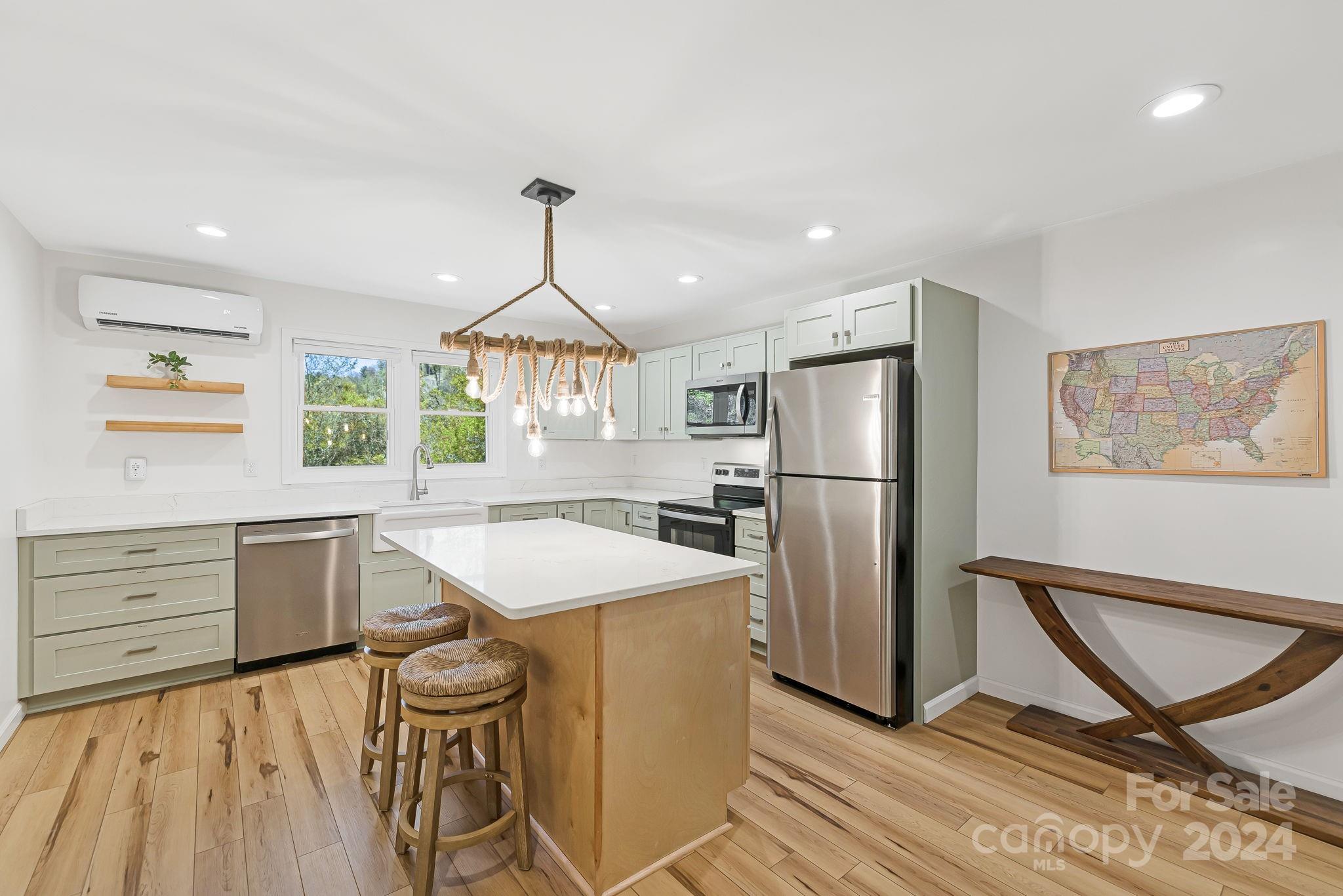850 East Fork Road Marshall, NC 28753 - Photo 24 of 48 a kitchen with a refrigerator a stove a sink dishwasher a dining table and chairs with wooden floor