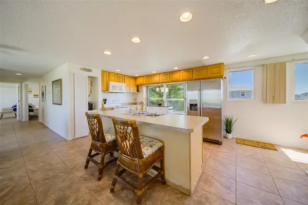 a dining hall with stainless steel appliances a dining table and chairs