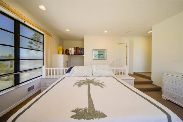 a spacious bedroom with a bed and a large window