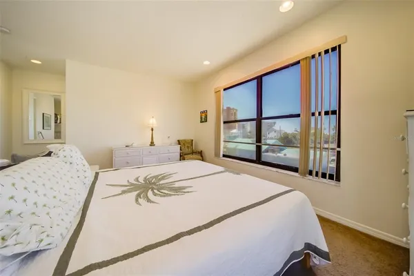 a bedroom with a bed and a large window
