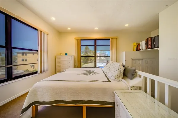 a bedroom with a bed and a large window
