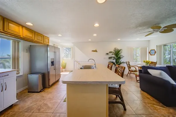 a kitchen with stainless steel appliances a table chairs refrigerator and sink