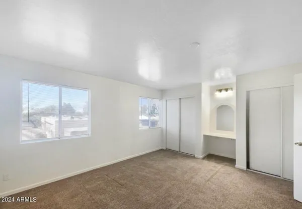 an empty room with windows and closet