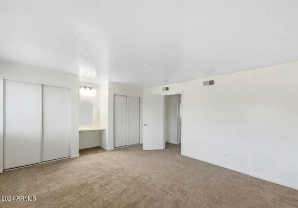 an empty room with closet and natural light