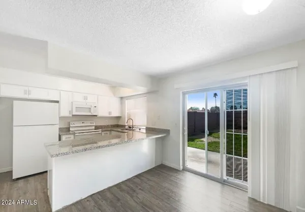 a kitchen with kitchen island granite countertop a stove a sink and a refrigerator