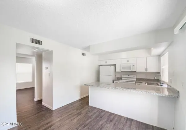 a kitchen with kitchen island a sink cabinets and wooden floor
