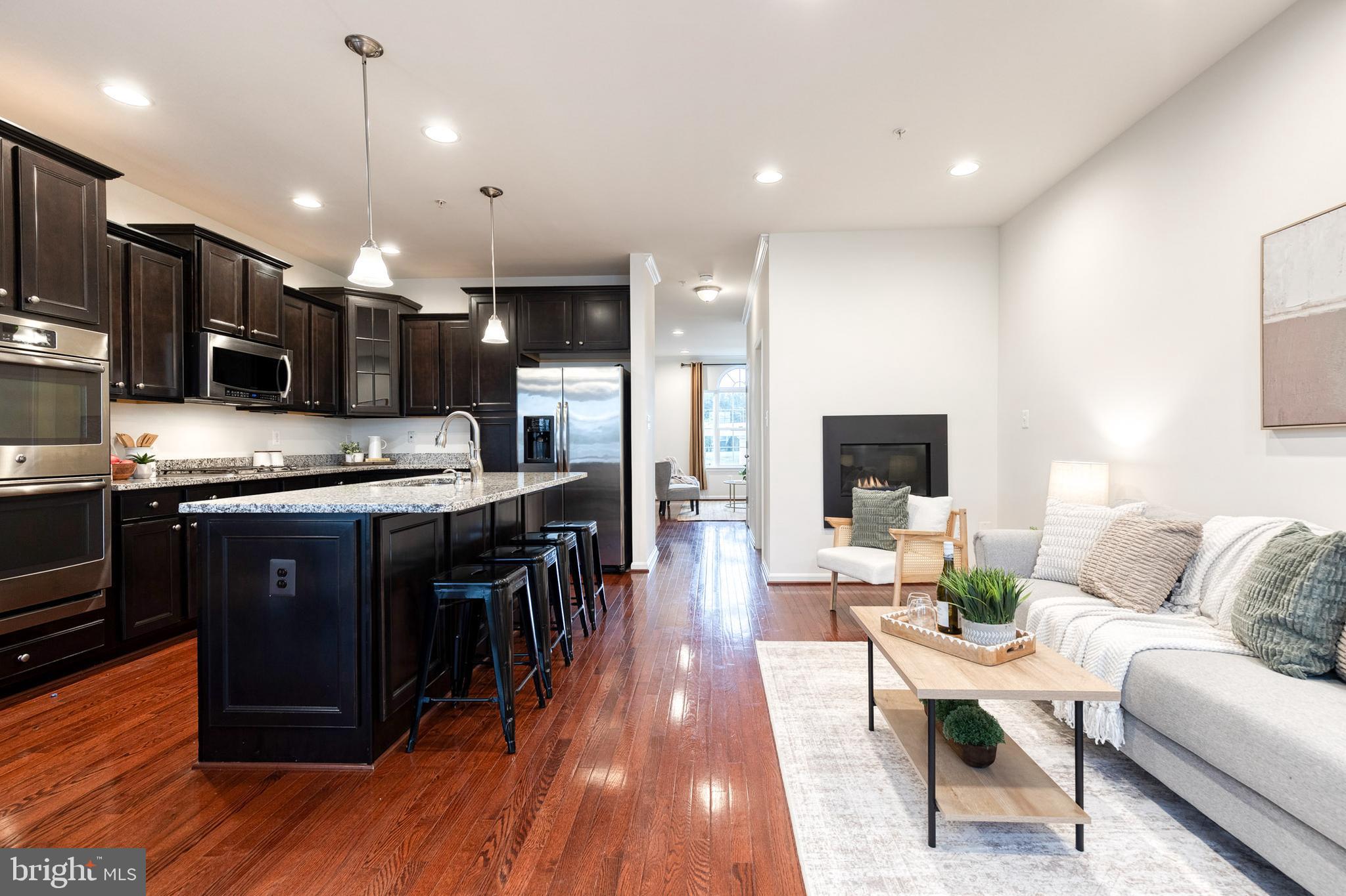 7951 Silver Oak Road Hanover, MD 21076 - Photo 16 of 41 a kitchen with stainless steel appliances kitchen island granite countertop a stove a sink a refrigerator and a microwave