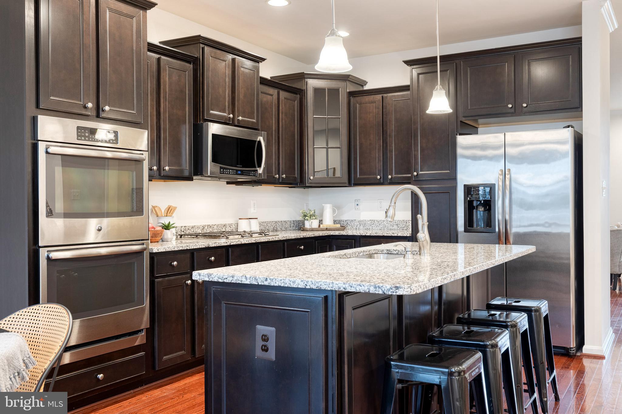 7951 Silver Oak Road Hanover, MD 21076 - Photo 6 of 41 a kitchen with kitchen island granite countertop a sink appliances and cabinets