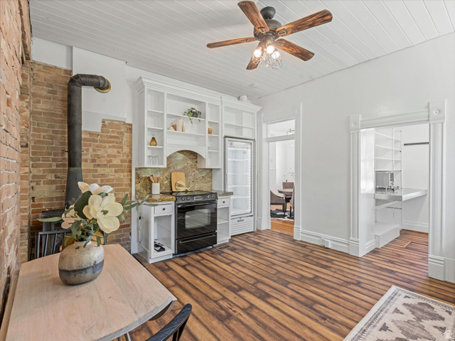 12825 South Fort Street Draper, UT 84020 - Photo 10 of 52 Open-concept living space featuring wood-finish flooring, a white beadboard ceiling, and a rustic wood-burning stove