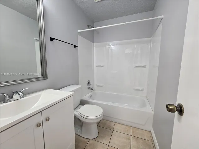 a bathroom with a bathtub shower sink vanity mirror and toilet