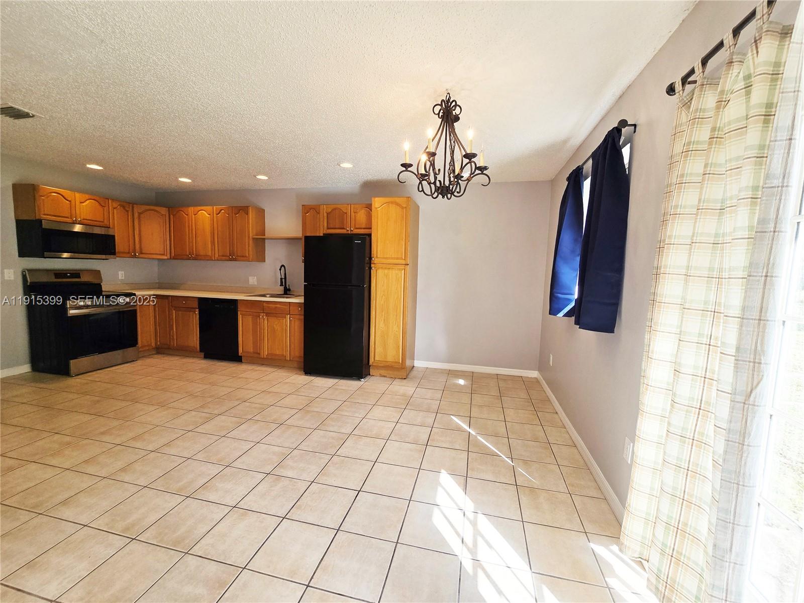 4548 Southeast Salvatori Road Stuart, FL 34997 - Photo 5 of 11 a kitchen with stainless steel appliances kitchen island granite countertop a refrigerator and a sink