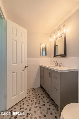 a bathroom with a sink a toilet and mirror