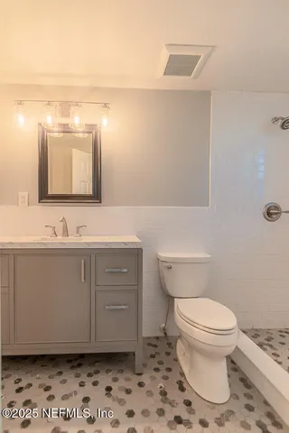 a bathroom with a sink a toilet and mirror