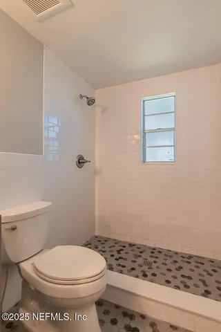 a bathroom with a toilet and a shower