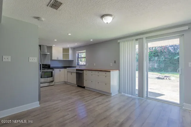 a view of kitchen with wooden floor and electronic appliances