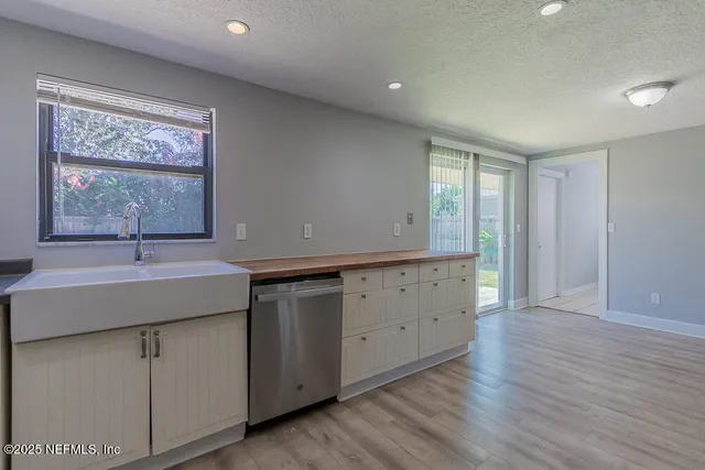 a room with a sink cabinets and a window