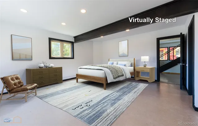 a spacious bedroom with a bed a couch and a large window