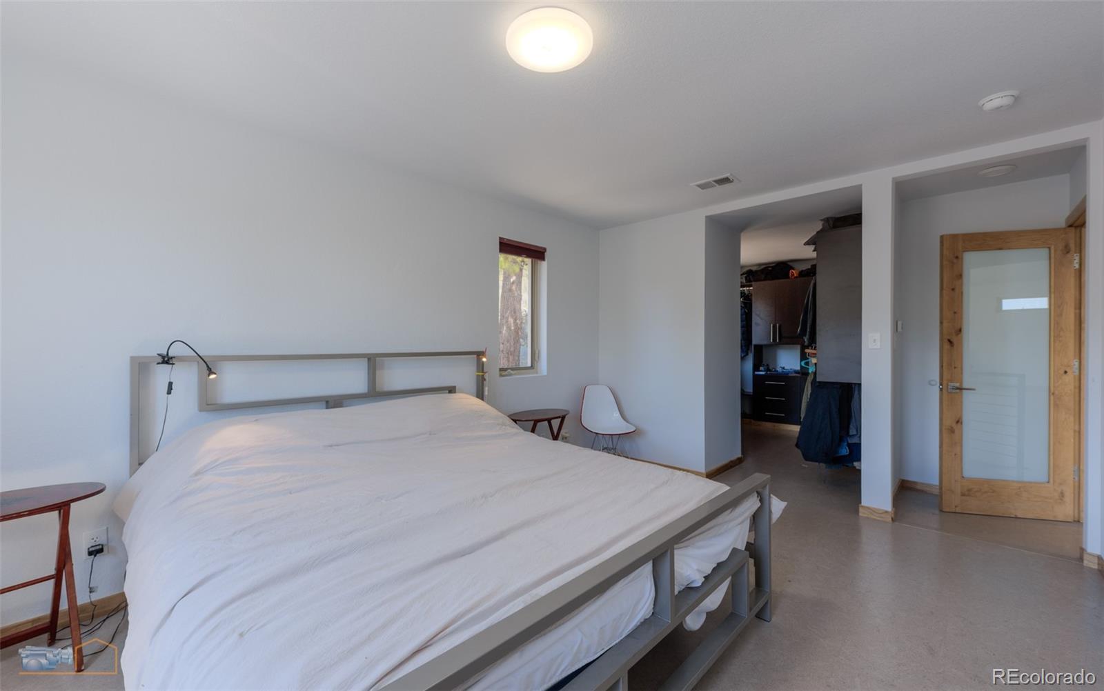 548 Coughlin Meadows Road Boulder, CO 80302 - Photo 38 of 50 a bedroom with a bed and a chandelier