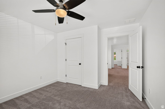6536 West Muirfield Road Highland, UT 84003 - Photo 23 of 48 Spacious room featuring neutral carpeting, white trim, a multi-blade ceiling fan, and a solid core door with black hardware
