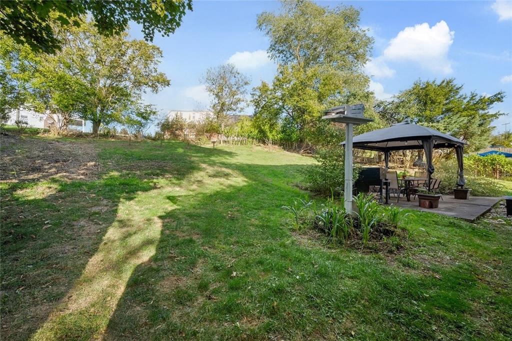 991 Forsythe Road Carnegie, PA 15106 - Photo 39 of 49 a view of a garden with a table and chairs under an umbrella