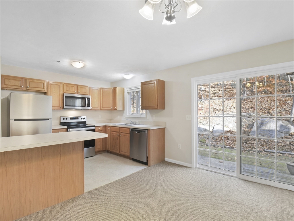 350 Riverbend Street, Unit 108 Athol, MA 01331 - Photo 4 of 27 a kitchen with stainless steel appliances granite countertop a stove top oven a sink dishwasher a refrigerator and white cabinets with wooden floor