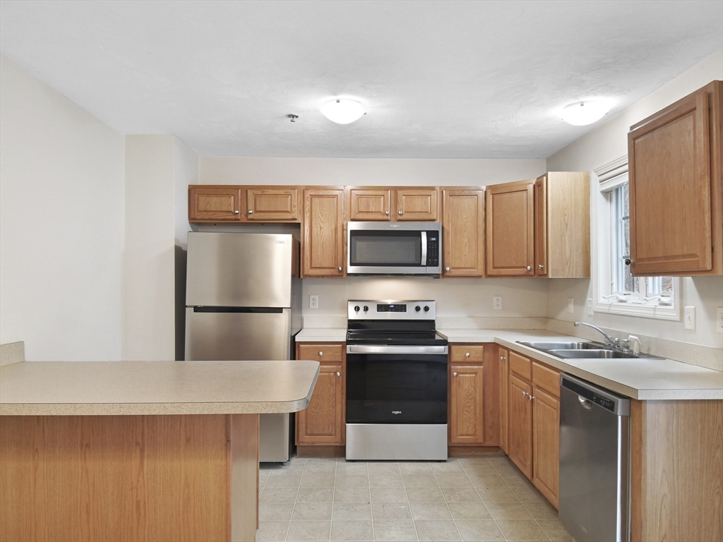 350 Riverbend Street, Unit 108 Athol, MA 01331 - Photo 7 of 27 a kitchen with stainless steel appliances a stove microwave and refrigerator