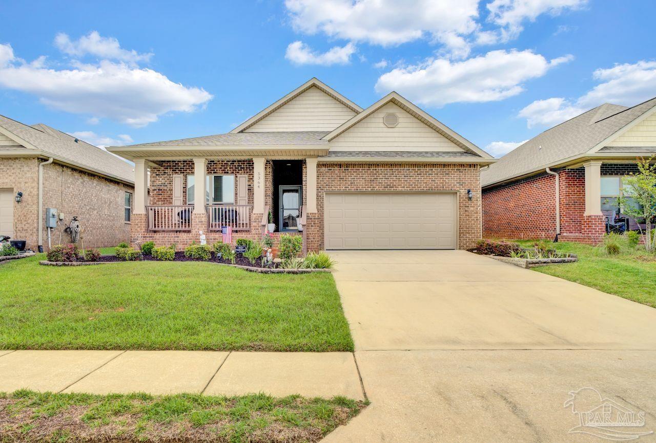 a front view of a house with a garden and yard