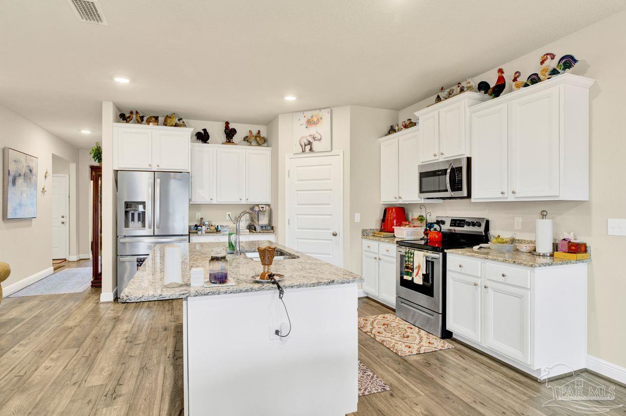 5364 Red Shoulder Road Pace, FL 32571 - Photo 30 of 46 a open kitchen with cabinets a sink and stainless steel appliances