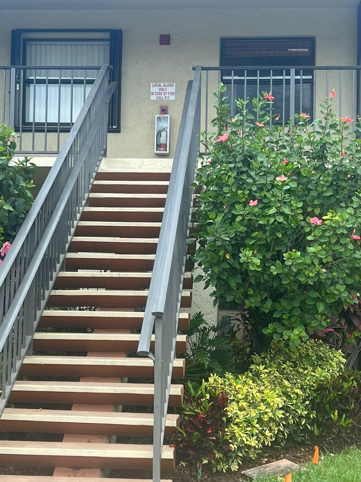 a view of stairs and flowers in front of house