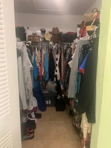 a view of walk in closet with clothes and shoes