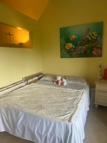 a room with a bed and painting on the wall