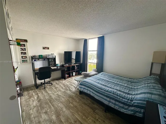 a bedroom with a bed furniture and a flat screen tv