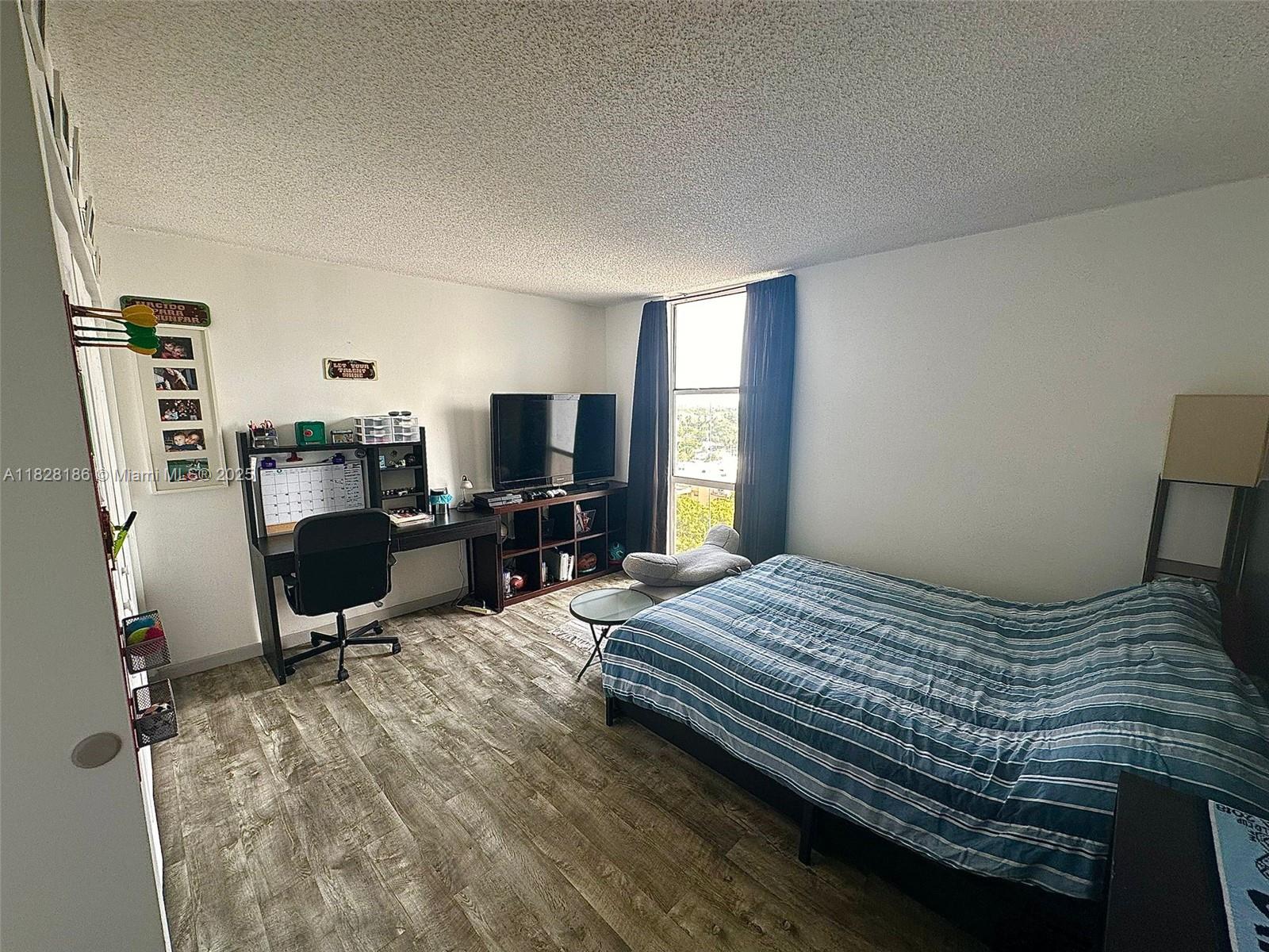 13499 Biscayne Boulevard, Unit 1013 North Miami, FL 33181 - Photo 11 of 25 a bedroom with a bed furniture and a flat screen tv