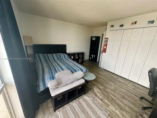 a bedroom with a bed and a flat tv screen on a dresser