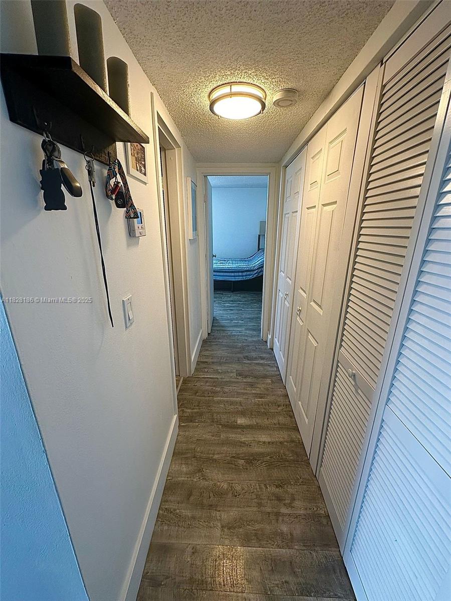 13499 Biscayne Boulevard, Unit 1013 North Miami, FL 33181 - Photo 13 of 25 a view of a hallway with wooden floor and staircase