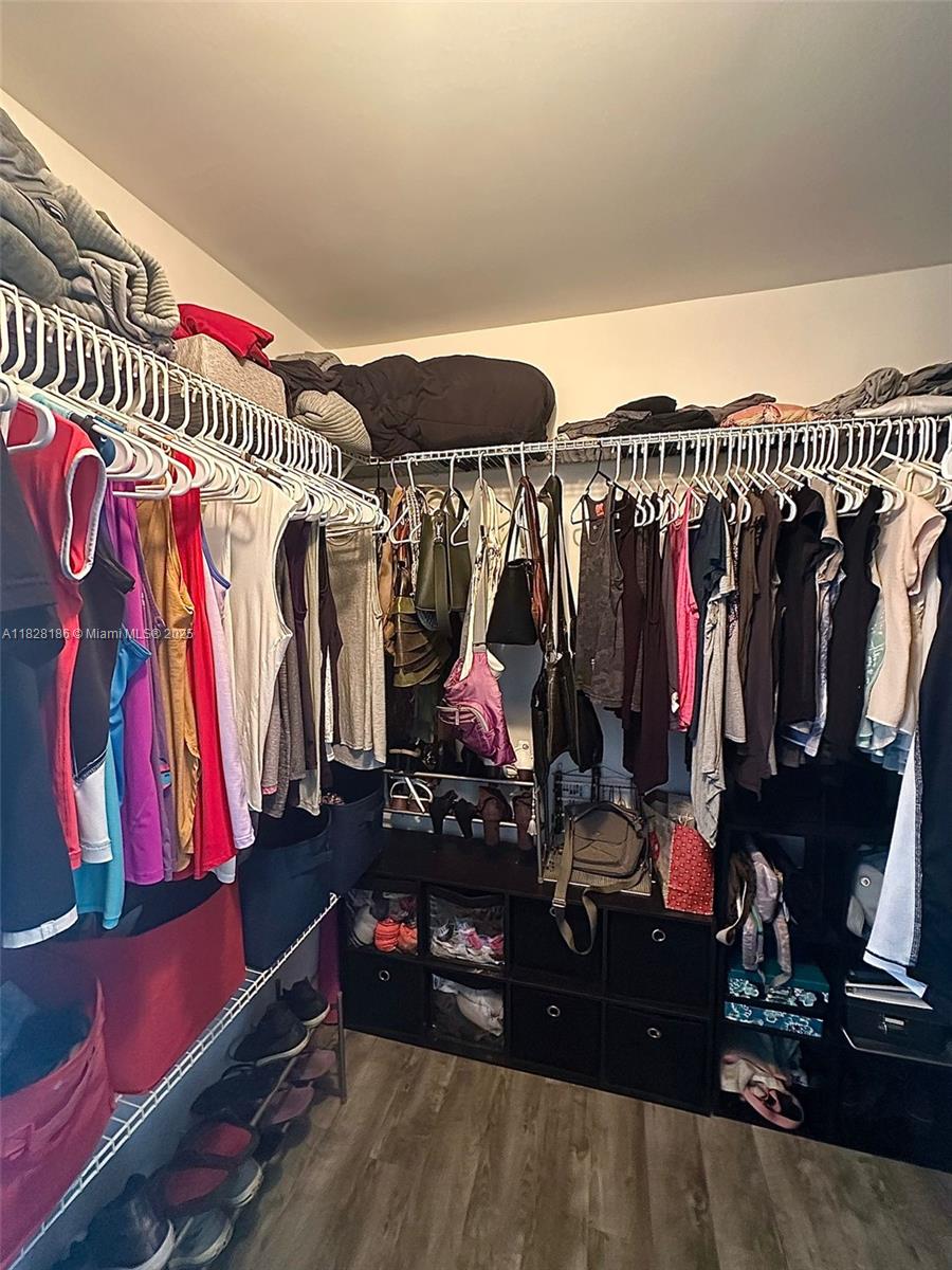 13499 Biscayne Boulevard, Unit 1013 North Miami, FL 33181 - Photo 19 of 25 a view of walk in closet with clothes and shoes